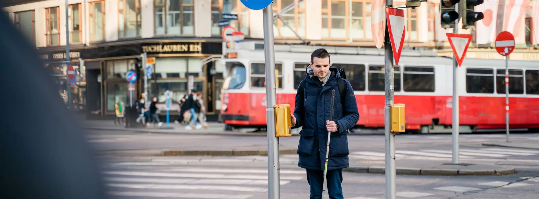 Blind person uses acoustic-tactile traffic light.