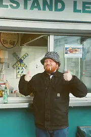 Chefkoch Lukas Mraz vor einem Würstelstand