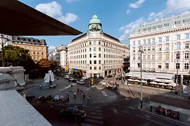 Exterior view of the Tourist Information Vienna on Albertinaplatz, horse-drawn carriage and pedestrians in the foreground
