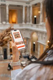 Dark-haired lady looking at the display of her smartphone.